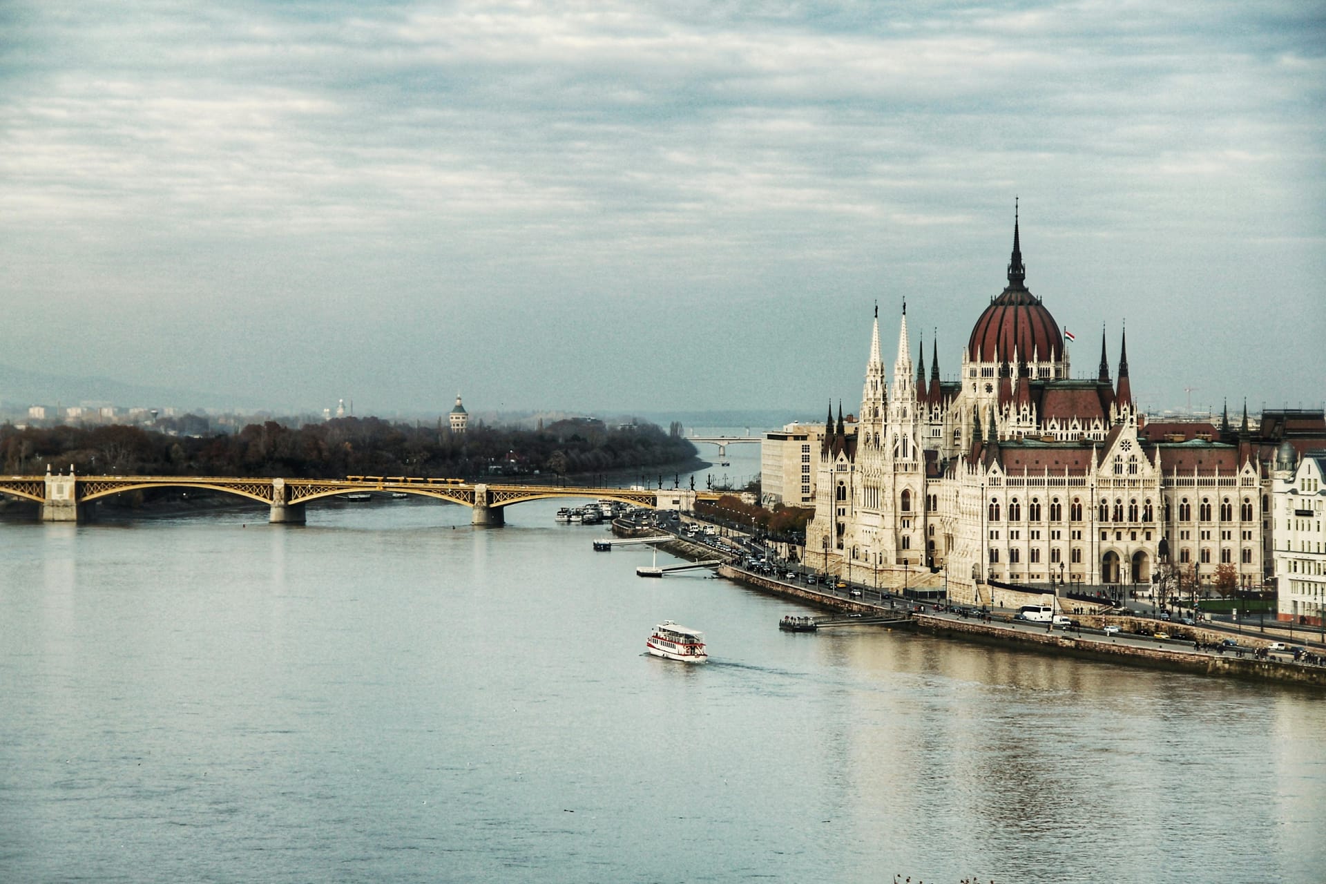 View of the Hungarian Parliament Building along the Danube River with Margaret Bridge and surrounding cityscape