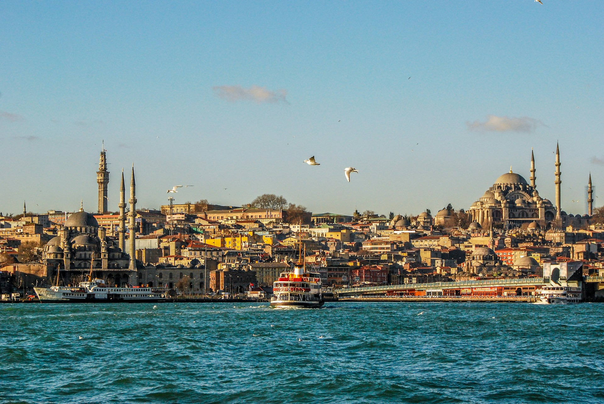 A view of the Bosphorus Strait with ferries moving across the turquoise water and the historic Istanbul skyline in the background.